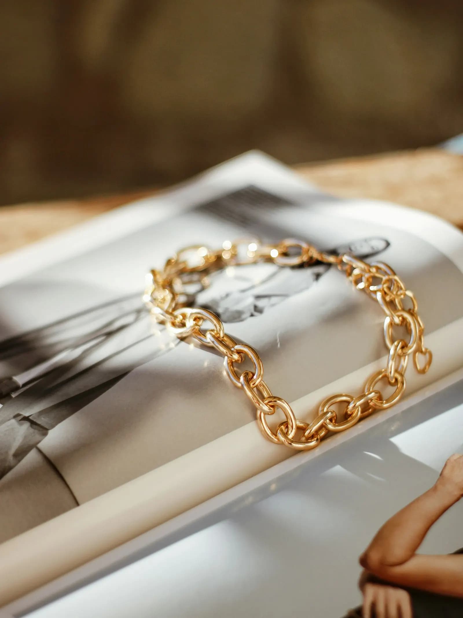 Gold chain bracelet resting on an open magazine